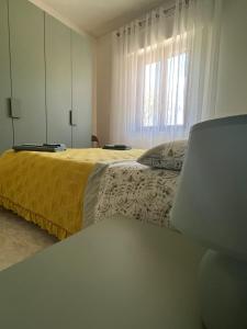 La Cannucciola في بيديلوكو: غرفة نوم بسرير اصفر ونافذة