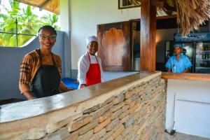 two women standing behind a counter in a restaurant at A casa di Giorgia lodge Nosy be Andilana in Nosy Be