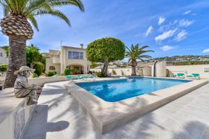貝尼薩的住宿－Villas Guzman - Altamira，一座别墅,设有游泳池和棕榈树