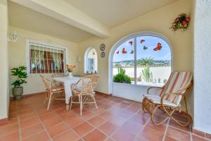 uma sala de jantar com uma mesa e cadeiras e uma janela em Villas Guzman - Altamira em Benissa