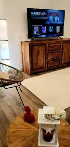 Suite dei Borboni - Appartamento في نابولي: غرفة معيشة مع تلفزيون وطاولة