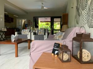 a living room with a purple bed and tables at Casa com serviço de praia e piscina privativa, Juquehy! in Juquei