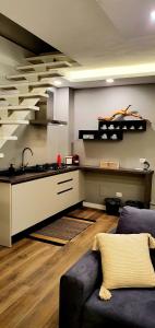 Suite dei Borboni - Appartamento في نابولي: غرفة معيشة مع أريكة ومطبخ