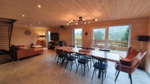 salon z dużym drewnianym stołem i krzesłami w obiekcie CHALET LES PRIMEVÈRES 4 Étoiles w mieście Gerbépal