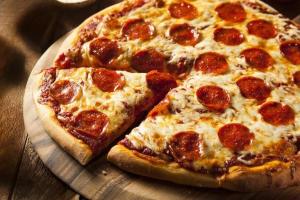 two slices of pepperoni pizza on a wooden table at Guesthouse Latphari in Ushguli +60 photos