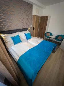 Una cama grande con una manta azul encima. en Boutique Apartments Old Town en České Budějovice
