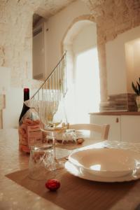 - une table avec une assiette et des verres à vin dans l'établissement Meraviglie del Sud, à Castellana Grotte