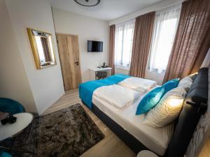 1 dormitorio con 1 cama grande con almohadas azules en Boutique Apartments Old Town en České Budějovice
