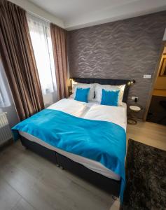 a bedroom with a large bed with blue and white sheets at Boutique Apartments Old Town in České Budějovice