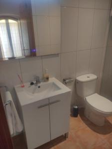 uma casa de banho com um lavatório branco e um WC. em APARTAMENT CAN MINGU 2on pis em Besalú