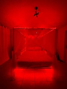 Cette chambre rouge comprend un lit et un ventilateur de plafond. dans l'établissement ATOAS - Lovely Vacation Retreat with Pool and Jacuzzi 5 min to Boqueron and Beaches, à Cabo Rojo