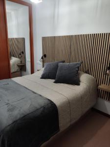 a bedroom with a bed with two pillows on it at Portosin Lar in Goyanes