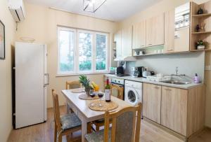 a kitchen with a table and chairs and a refrigerator at Madrid 90 Sq M 2BDR w Parking Spot near Metro, Serdika Mall in Sofia