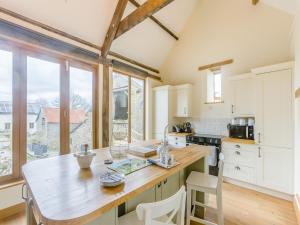 a kitchen with a large table and a large window at Olive Barn in Witheridge