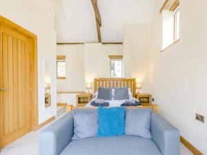 - une chambre avec un lit et un canapé bleu dans l'établissement Olive Barn, à Witheridge