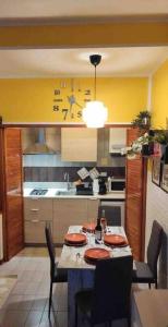 uma cozinha com uma mesa com cadeiras e um relógio na parede em Apartment Il Monte Old Bridge em Florença