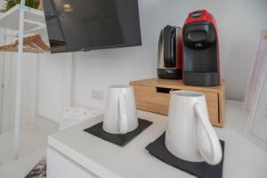 eine Küche mit zwei weißen Vasen auf einer Theke mit einer Mikrowelle in der Unterkunft Light Garden in Taormina