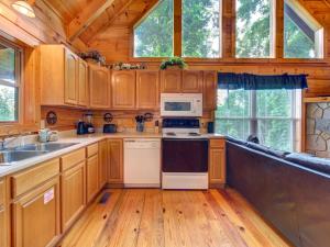 a kitchen with wooden cabinets and a stove top oven at The Vinson, 1 Bedroom, Loft, Game Room, Hot Tub, Theater Room, Sleeps 4 in Gatlinburg