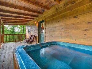 a swimming pool on the deck of a log cabin at The Vinson, 1 Bedroom, Loft, Game Room, Hot Tub, Theater Room, Sleeps 4 in Gatlinburg