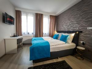 a hotel room with a bed and a desk and window at Boutique Apartments Old Town in České Budějovice