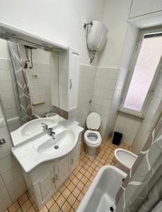 La salle de bains blanche est pourvue d'un lavabo et de toilettes. dans l'établissement Rhome Holiday Fornaci, à Rome