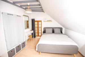 sypialnia z łóżkiem, komodą i lustrem w obiekcie Maison de charme en Bourgogne w mieście Vincelottes