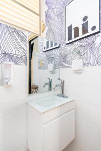 La salle de bains est pourvue d'un lavabo et d'un miroir. dans l'établissement ATOAS - Lovely Vacation Retreat with Pool and Jacuzzi 5 min to Boqueron and Beaches, à Cabo Rojo