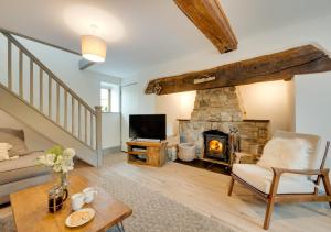 a living room with a fireplace and a tv at Bythynnod Aderyn Cottages in Cemmaes