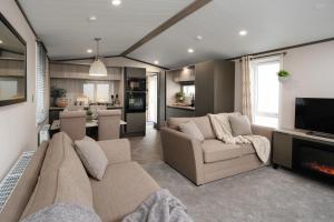 a living room with a couch and a tv at Bailey Lodge in Padstow