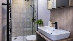 a bathroom with a sink and a shower at Bailey Lodge in Padstow