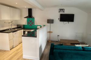 a kitchen and living room with a green couch in a room at Victoria Street Apartments in Morecambe