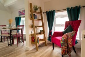 a living room with a red chair and a table at Victoria Street Apartments in Morecambe
