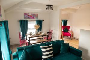 a living room with a green couch and a table at Victoria Street Apartments in Morecambe
