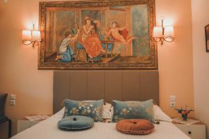a bedroom with a painting above a bed with pillows at Nafsika Apartments in Parga