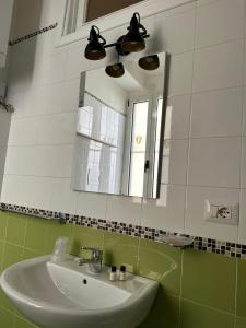 a bathroom with a sink and a mirror at Le Dimore Del Gufo - La Cattedrale in Venosa