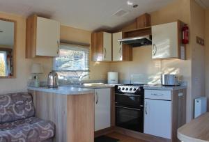 a small kitchen with a sink and a stove at Crannich Holiday Caravans in Killichronan