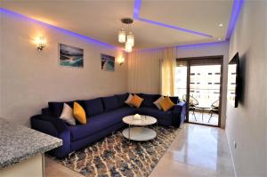 sala de estar con sofá azul y mesa en Royal Deluxe Platinum - Pearl Garden Marrakech, en Marrakech