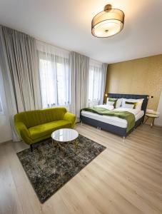 ein Schlafzimmer mit einem Bett, einem Sofa und einem Tisch in der Unterkunft Boutique Apartments Old Town in Budweis