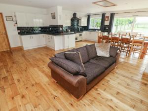 a living room with a couch and a kitchen at Ty Mawr in Haverfordwest