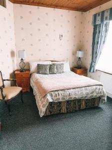 a bedroom with a large bed and a chair at St Anthonys B&B in Dungarvan