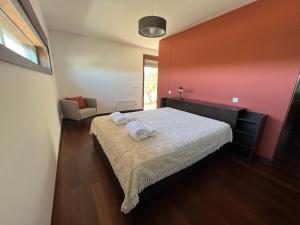 ein Schlafzimmer mit einem Bett mit zwei Handtüchern darauf in der Unterkunft Villa Martins in Lagoaça