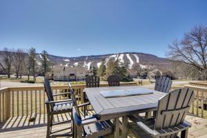 a table and chairs on a deck with a view of a mountain at Charming Townhome - Walk to Greek Peak Mountain! in Cortland