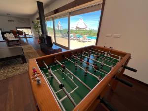 a pool table in a living room with a view of the pool at Villa Martins in Lagoaça