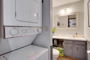 a bathroom with a sink and a toilet and a mirror at Charming Townhome - Walk to Greek Peak Mountain! in Cortland