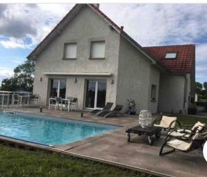 ein Haus mit einem Pool vor einem Haus in der Unterkunft Superbe maison Châtillon-Le-Duc 