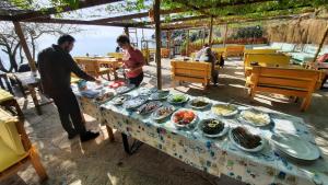 un paio di persone in piedi a un tavolo con del cibo di Özen Boyabağı a Kösedere