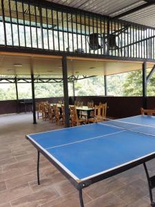 una mesa de ping pong azul en una habitación con mesas y sillas en SAN FELIPE CASA QUINTA, en Ibagué