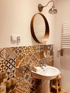a bathroom with a sink and a mirror at Restauracja Pensjonat Buda in Krosno