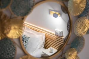 a mirror reflection of a bed with a pillow at Light Garden in Taormina