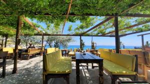 un restaurant avec une table et des chaises et l'océan dans l'établissement Özen Boyabağı, à Kösedere